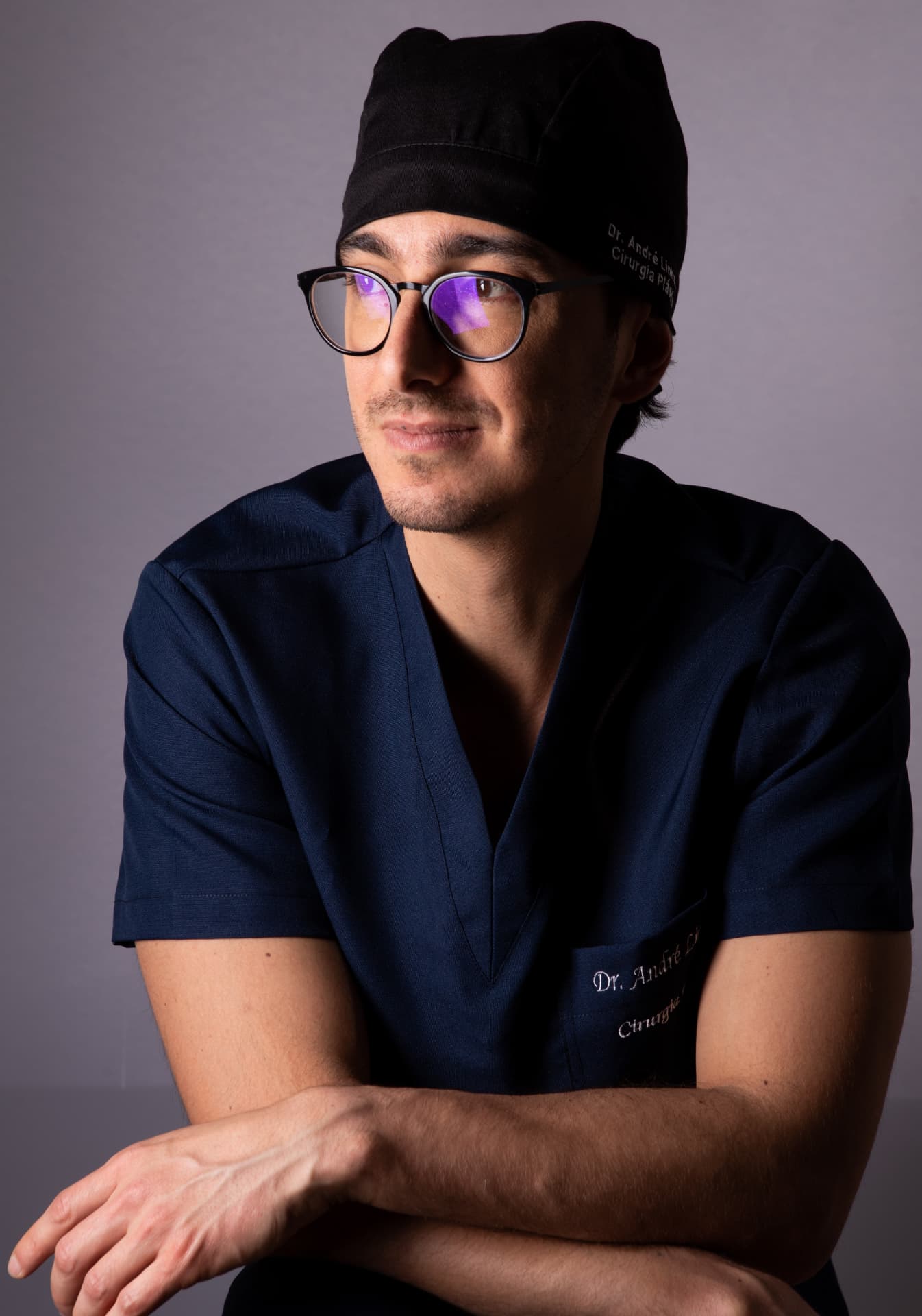 Dr. André Linhares, cirurgião plástico em Toledo e Palotina, com touca cirúrgica e os braços cruzados